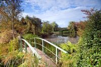 Picturesque aboretum large pond and Monet bridge with autumn colour from trees and shrubs at Wilkins Pleck (NGS) Whitmore near Newcastle-under-Lyme in North Staffordshire