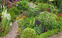 A cottage garden with borders of mixed herbaceous perennials at Coley Cottage, NGS, Little Haywood, Staffordshire 