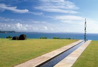 A rill of water with an infinity edge, overlooking the sea with sculptural focal point - New Zealand