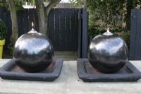Large spherical oil burners on table on roof terrace in summer.

