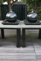 Large spherical oil burners on table on roof terrace in summer. 


