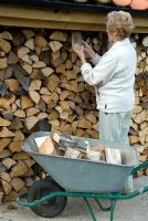 Woman collecting firewood from store