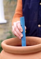 Planting a strawberry planter with herbs - Take a one inch plastic pipe and cut so it's long enough to be just above the final level of compost, then drill holes in the sides so it acts like a colander. Insert the pipe in the centre of the pot