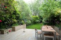 Large urban garden with furniture on patio. The Merrick Garden, London, UK