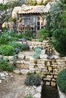 Steps through sloping Mediterranean style garden planted with Lavandula - Lavender, Thymus - Thymes and Olive trees. The L'Occitane Garden, Silver medal winner at RHS Chelsea Flower Show 2010 
 
