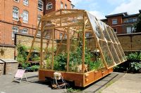 Travelling greenhouse, pulled by people, parked in St Lukes Community Allotments, Clerkenwell, London Borough of Islington, UK