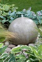 Round stone water feature amongst Hosta and Stipa tenuissima - The Urban Retreat, Bronze medal winner at RHS Hampton Court Flower Show 2010