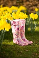 Patterned pink woman's wellies alongside Daffodils in spring