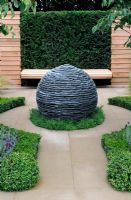 Ornamental Lakeland stone sphere in formal garden. RHS Tatton Park Flower Show 2010