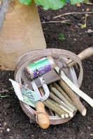 Wooden trug with hazel stick markers, garden twine, seeds and tools