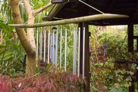 Wind chimes hanging from Pergoda at oriental themed garden - Four Seasons, Staffordshire, NGS