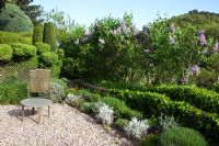 Gravel patio surrounded by clipped shrubs - La Louve Garden, Provence, France