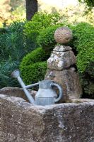 Stone trough and watering can - La Louve Garden, Provence, France