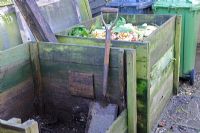 Wooden compost bins situated next to wheelie bins 