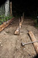 Building a raised bed - Knock in posts against a line at intervals to support the side planks 