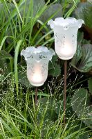Ornate glass lights in border with grasses
