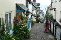 Clovelly's steep cobbled street leads down to a picturesque harbour. Clovelly Court, Bideford, Devon, UK
