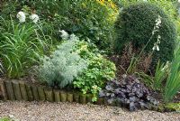 Gravel path and border on a slope with log roll edge and planting with Hydrangea 'Vanilla Fraise', Artemisia 'Powis Castle', Galtonia candicans, Heuchera obsidian and Rudbeckia fulgida 'Goldsturm' at Church View, Appleby-in-Westmorland, Cumbria NGS