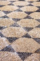 Decorative design of pebbles set in cement