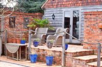 Wicker chairs on raised patio with rope railings 