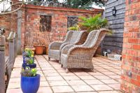 Wicker chairs on raised patio with rope railings 
