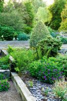 Weathered railway sleepers make raised beds mulched with blue slate chippings. Planting includes Buxus sempervirens 'Elegantissima' - Ivy Croft, Leominster, Herefordshire, UK