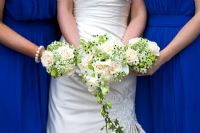 Bride and bridesmaids holding a wedding bouquet with Roses, Ornithogalum, Ivy and lilies