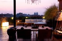 Terrace with contemporary seating area with sofas at night with modern lighting in Ferrara, Italy 