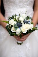 Bride holding a wedding bouquet of white  Roses, Carnation and Eryngium