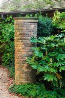 Cylindrical brick entrance pier with Fatsia japonica
