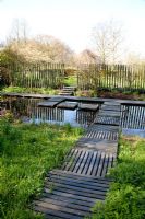 Natural wildlife pond with decked stepping stones. Mien Ruys Tuinen, Dedemsvaart, Netherlands
