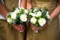 Bridesmaids holding bouquets of white roses