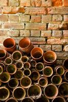 Pots stacked against brick wall - Holbeach Hurn, Lincolnshire, UK 
