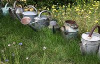 Line of metal watering cans in the 'Sculptillonnage' garden - Festival International des Jardins de Chaumont sur Loire, France 2011