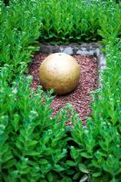 Gold sphere surrounded by Sedum - The Laskett, near  Hereford, Herefordshire, UK. Private garden of Sir Roy Strong. June. 