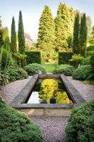 'Italian Garden' with reflecting pool and green and white planting. Structure provided by Taxus - Yew hedges, Cupressus sempervirens, Hebe sutherlandii and standard Ligustrum delavayanum - Greenways garden, Cheshire 
