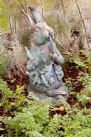 Rabbit statue of Peter Rabbit in vegetable patch with carrots