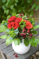 Bouquet of red Roses and Gerbera on old wooden table outdoors