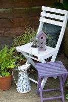 White seat with purple bird house and stool