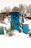 Blue shed on allotment covered in snow