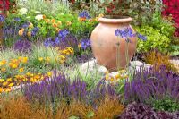 Ornamental urn in colourful summer garden 