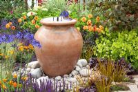 Decorative urn water feature in Mediterranean style garden 