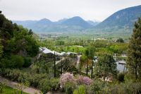 The Botanical gardens of Trauttmansdorff Castle in Merano, Italy viewed from above against the panorama of the South Tyrolian alps