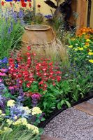 Large, water filled glazed pot in flower beds in the 'Painting With Plants Garden' - RHS Tatton Park Flower Show 2011