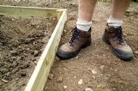 step by step, making a raised bed - firming soil with feet
