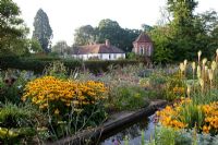 The old potager garden with mixed perennials, overlooked by brick built tower - Penpergwm Lodge, Monmouthshire. Autumn