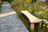 Timber bench surrounded by Anthemis and Ox-eye daisies and path of stone setts - 'Stitch in Time Saves Nine' garden - RHS Tatton Park Flower Show 2011 
 