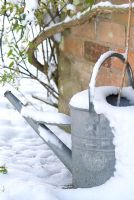 Galvanised watering can in the snow. Gowan Cottage