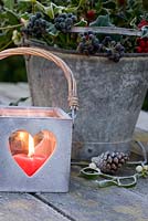 Heart shaped tea light holder with lighted heart candle and christmas foliage