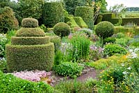 The Flower Garden features strong blocks of box and yew that frame cottage garden plants and flowers, including Achillea, Lychnis and Saxifraga - Herterton House, Hartington, Northumberland, UK